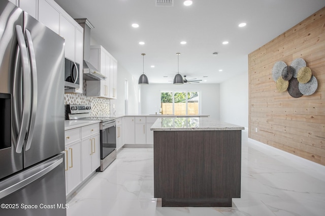 kitchen with pendant lighting, wooden walls, white cabinets, kitchen peninsula, and stainless steel appliances