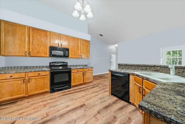 kitchen featuring sink, light hardwood / wood-style flooring, black appliances, vaulted ceiling, and a chandelier