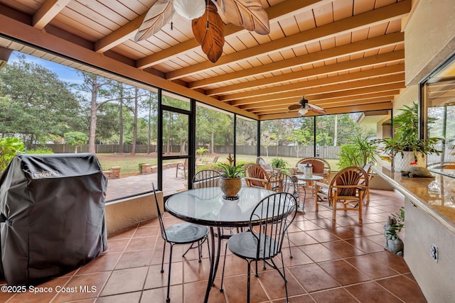 sunroom featuring wood ceiling, ceiling fan, and beam ceiling