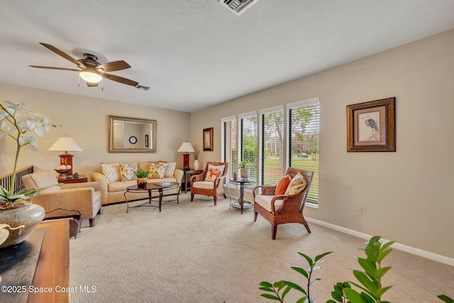 carpeted living room featuring ceiling fan and a textured ceiling