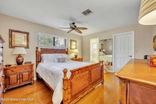 bedroom with connected bathroom, ceiling fan, and light hardwood / wood-style flooring