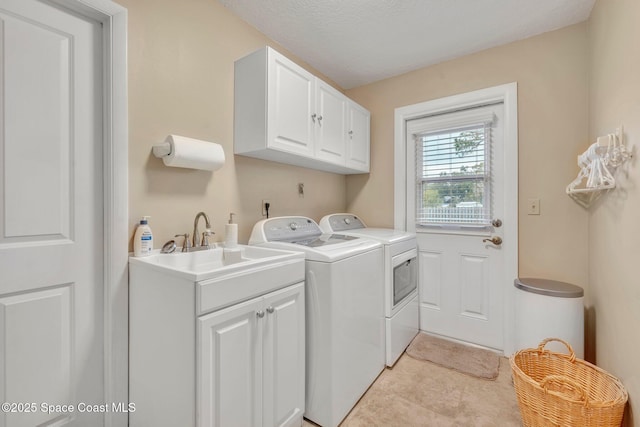 washroom with cabinets, washer and dryer, sink, and light tile patterned floors