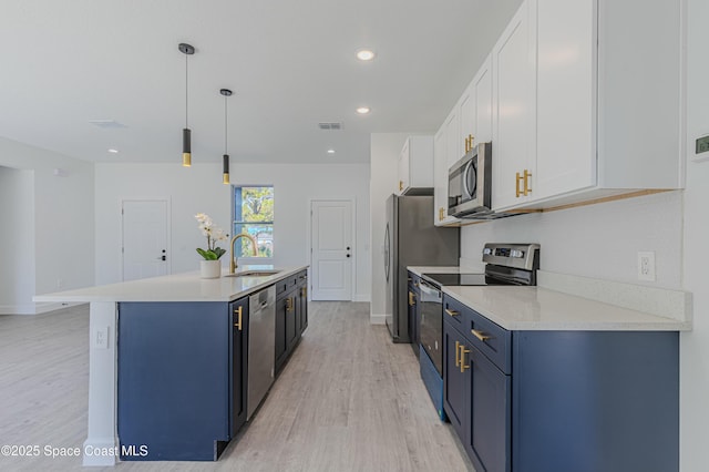 kitchen with sink, white cabinetry, hanging light fixtures, light hardwood / wood-style flooring, and appliances with stainless steel finishes