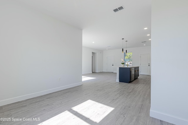 unfurnished living room with sink and light wood-type flooring