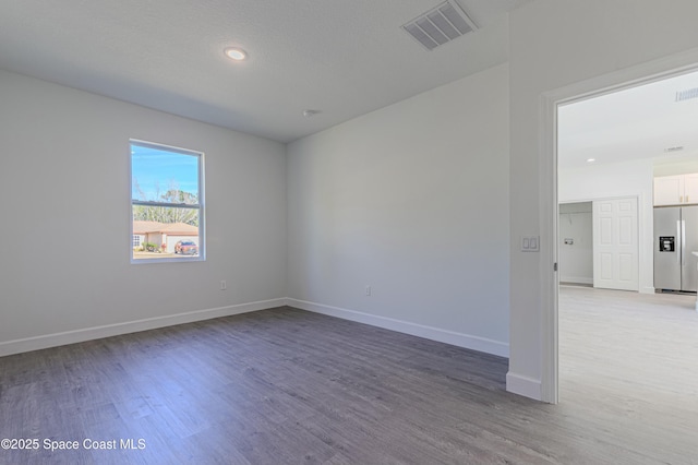 unfurnished room with wood-type flooring