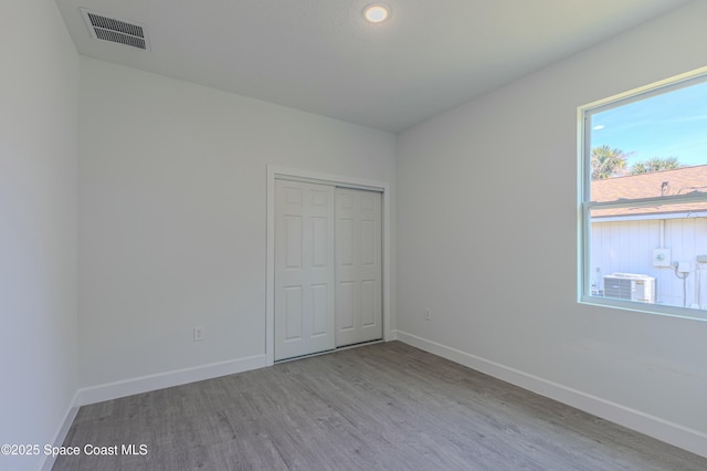 unfurnished bedroom with a closet and light wood-type flooring