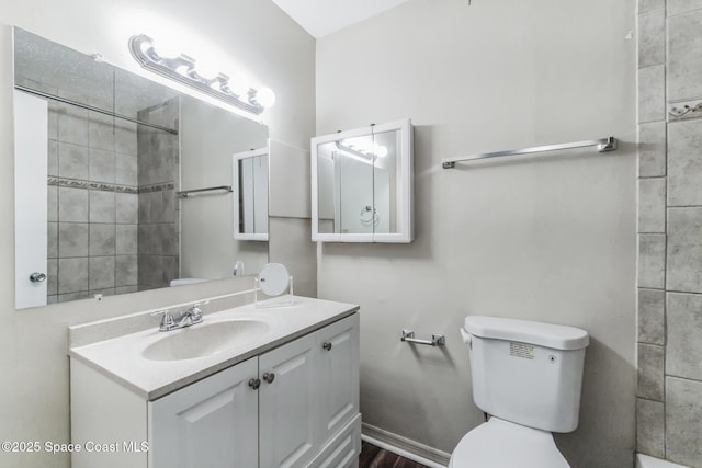 bathroom featuring vanity, toilet, and tiled shower