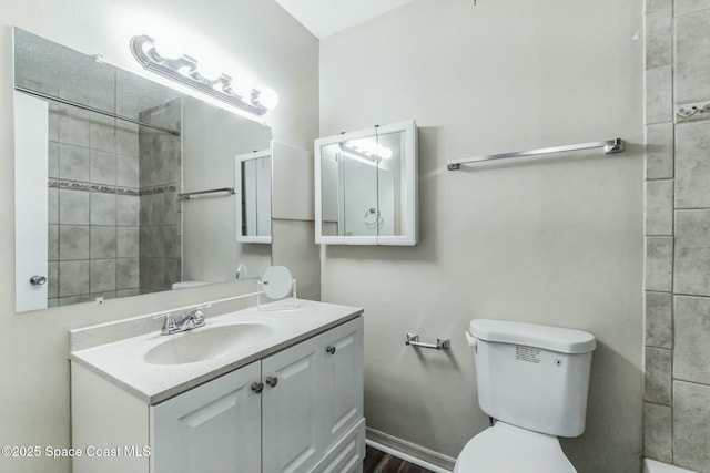 bathroom with vanity, a tile shower, and toilet