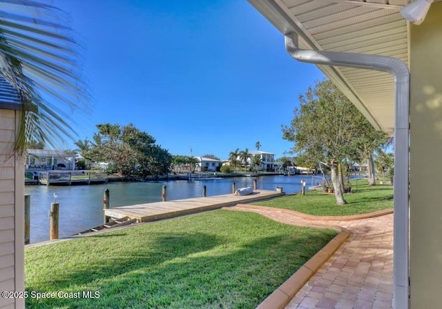 view of yard featuring a water view and a dock