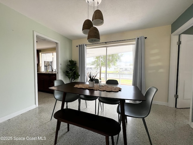 dining area featuring sink and a textured ceiling