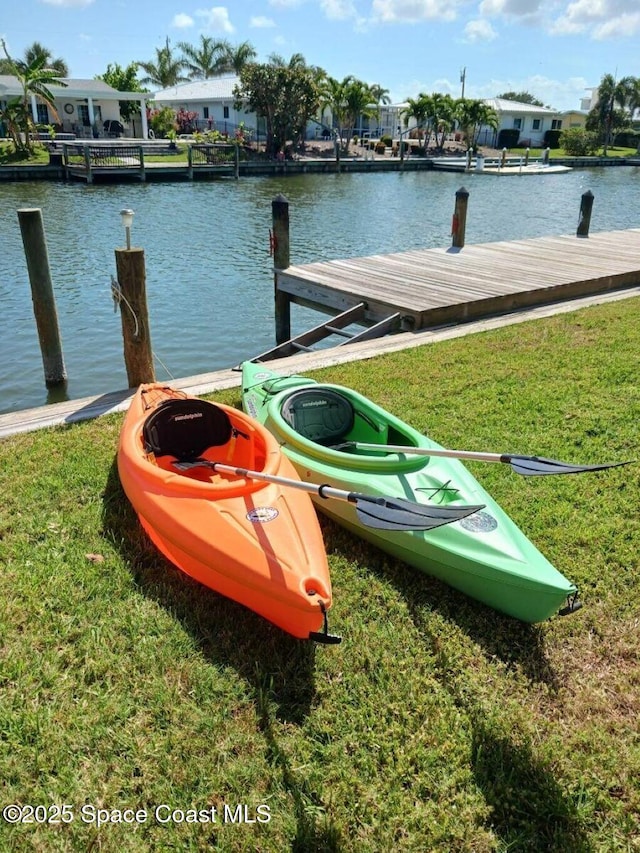 dock area with a lawn and a water view