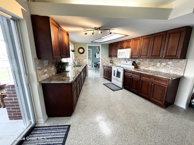 kitchen featuring light stone counters, sink, white appliances, and backsplash