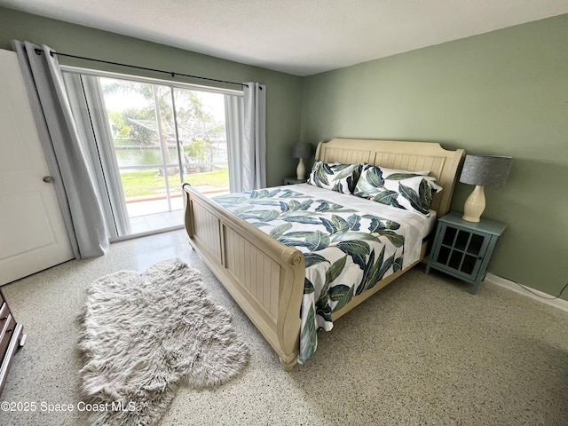 bedroom with access to exterior and a textured ceiling