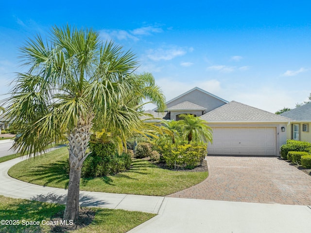 7105 Mendell Way, Melbourne, FL 32940 - view of front of house featuring decorative driveway, a shingled roof, an attached garage, a front yard, and stucco siding
