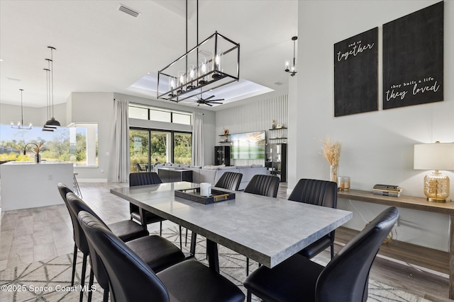 dining room with an inviting chandelier, sink, and a tray ceiling