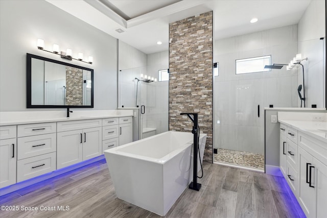 bathroom featuring wood-type flooring, independent shower and bath, and vanity