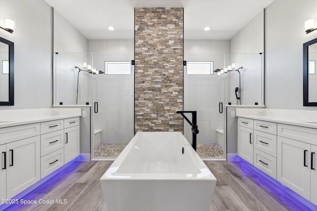 bathroom with vanity, separate shower and tub, and hardwood / wood-style floors