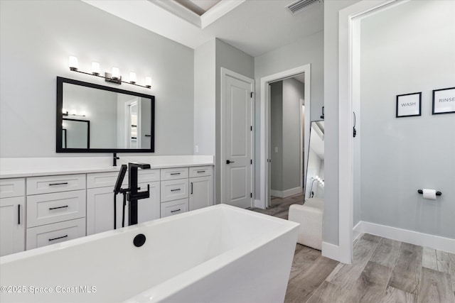 bathroom with vanity, hardwood / wood-style floors, and a bathtub