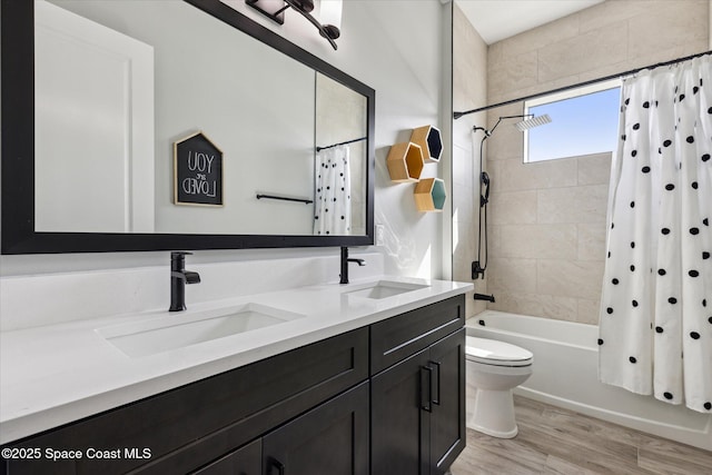 full bathroom featuring wood-type flooring, toilet, shower / bath combination with curtain, and vanity