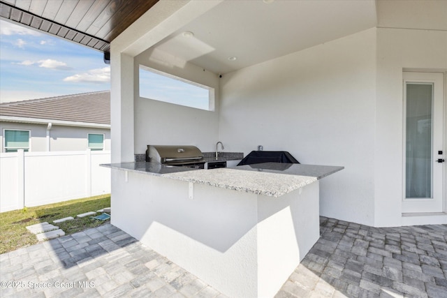 view of patio / terrace featuring an outdoor kitchen and a grill