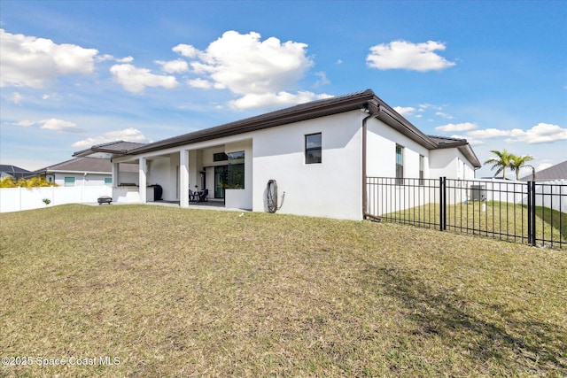 rear view of house with a patio and a lawn