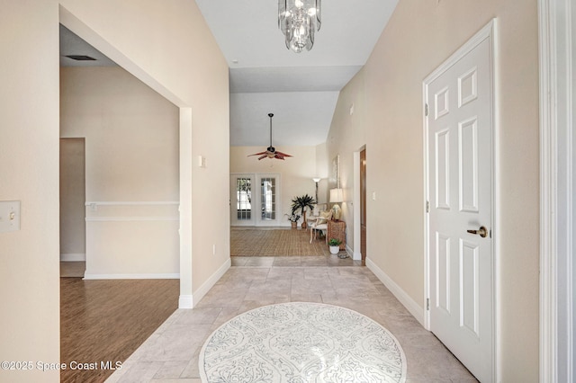 corridor featuring light tile patterned flooring and an inviting chandelier