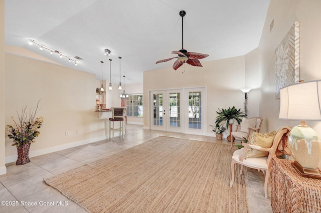 living area with french doors, ceiling fan, and light tile patterned floors