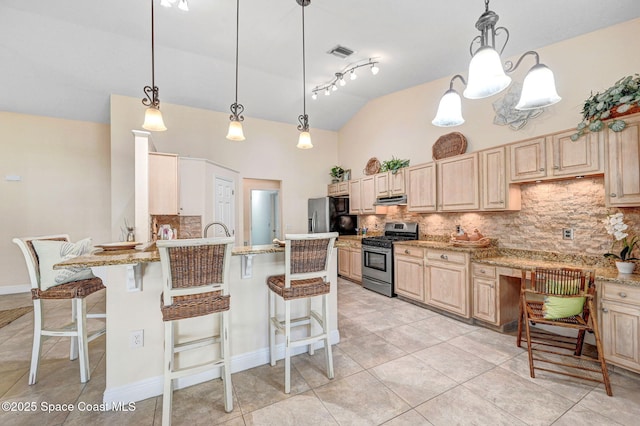 kitchen featuring pendant lighting, light brown cabinetry, light stone countertops, and appliances with stainless steel finishes