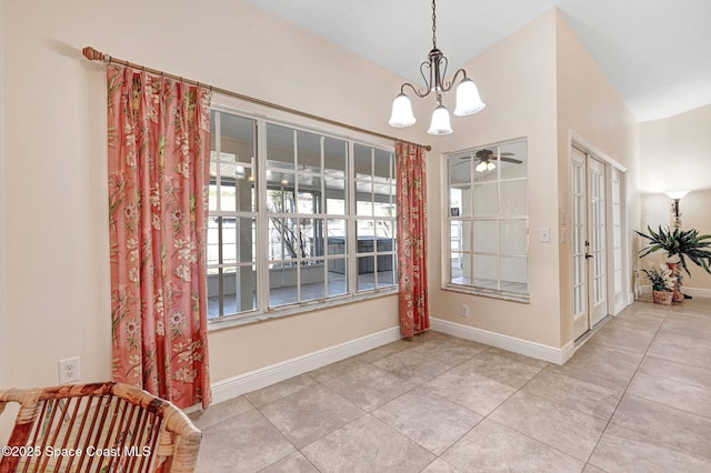 tiled dining room with ceiling fan with notable chandelier and vaulted ceiling