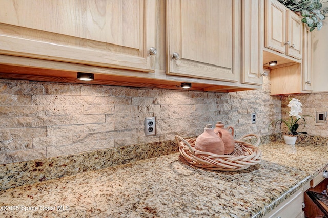 interior details featuring tasteful backsplash, light stone counters, and light brown cabinets