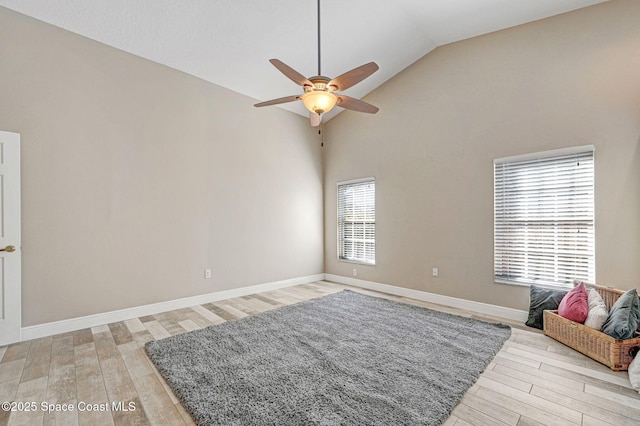 living room with ceiling fan, high vaulted ceiling, and light wood-type flooring