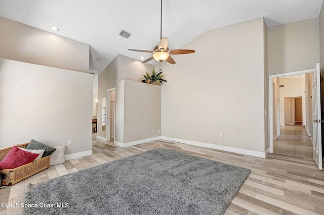 living room with ceiling fan, light wood-type flooring, and high vaulted ceiling