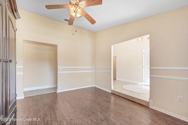 unfurnished room featuring dark wood-type flooring and ceiling fan