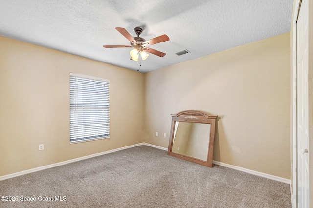 carpeted spare room featuring a textured ceiling and ceiling fan