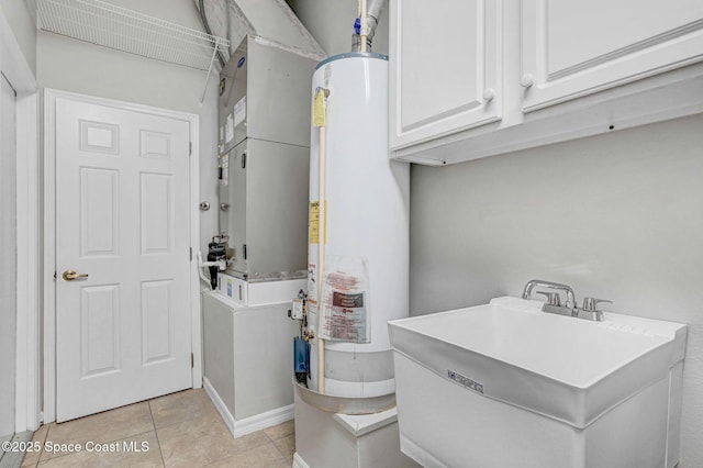 bathroom with gas water heater, sink, and tile patterned floors