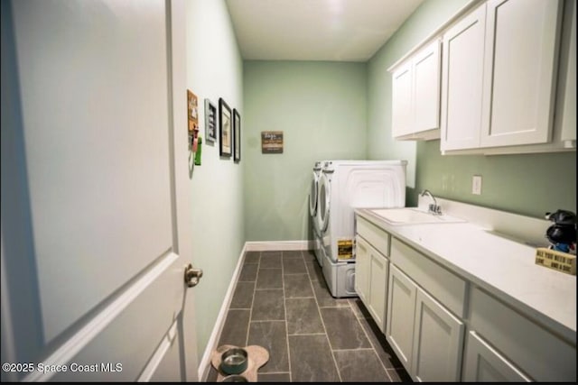 washroom with cabinets, separate washer and dryer, and sink