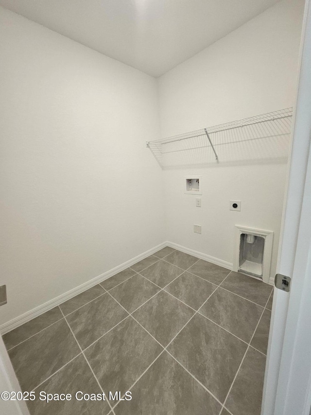 washroom with washer hookup, hookup for an electric dryer, and dark tile patterned floors