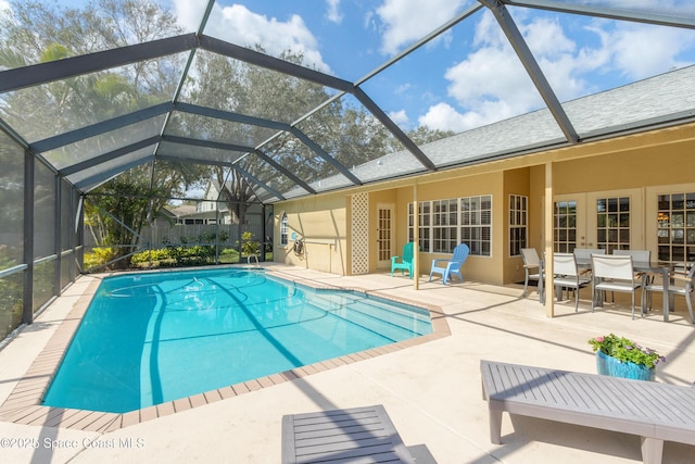 view of pool featuring a lanai, a patio area, and french doors