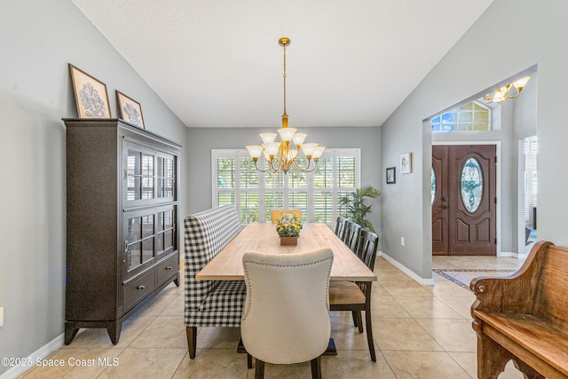 dining area featuring an inviting chandelier, light tile patterned floors, and vaulted ceiling