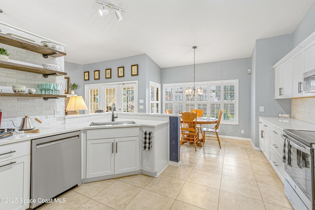 kitchen with french doors, sink, white cabinetry, hanging light fixtures, and appliances with stainless steel finishes