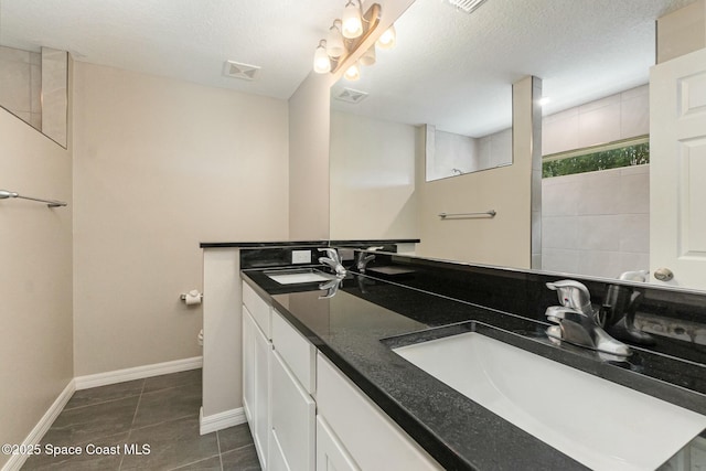 bathroom with vanity, tile patterned floors, and a textured ceiling