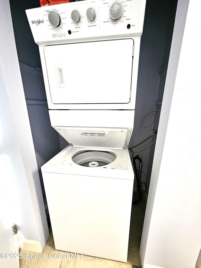 washroom featuring stacked washer and clothes dryer