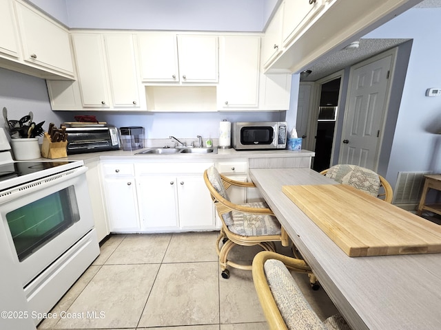 kitchen with sink, white cabinets, and white electric range oven