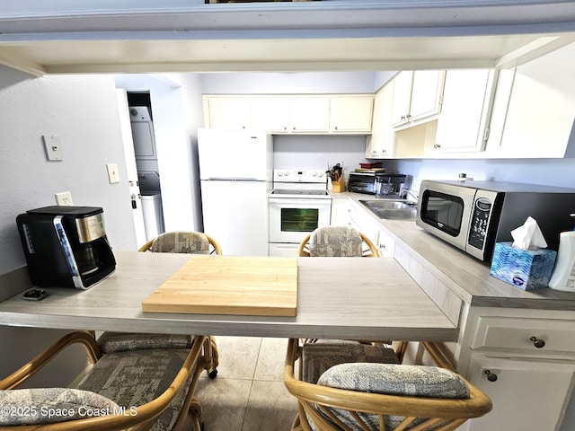 kitchen with white cabinetry, white appliances, and sink