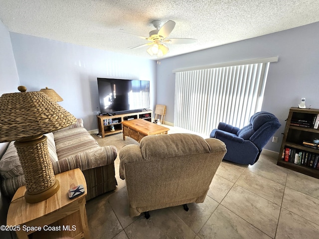 living room with ceiling fan, tile patterned flooring, a textured ceiling, and a wealth of natural light