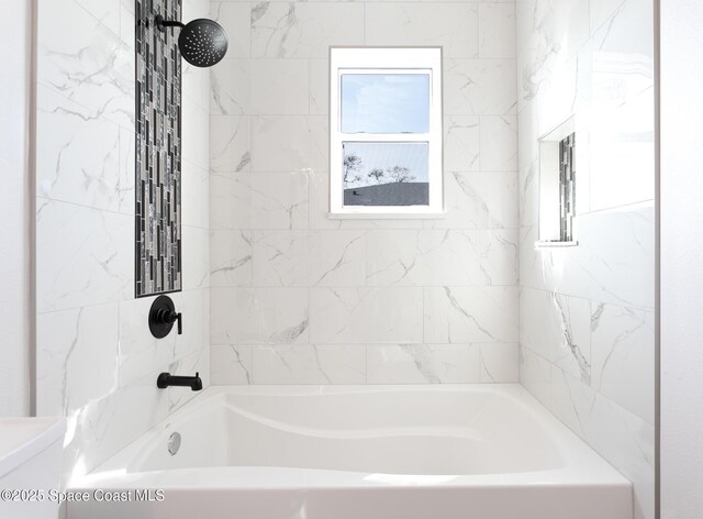 bathroom featuring tiled shower / bath, plenty of natural light, and toilet