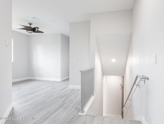 staircase with wood-type flooring and ceiling fan