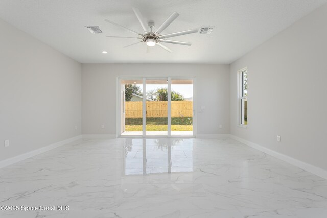 empty room with a textured ceiling and ceiling fan