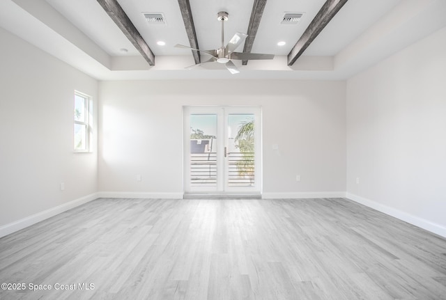 unfurnished room featuring beam ceiling, light hardwood / wood-style floors, and a wealth of natural light