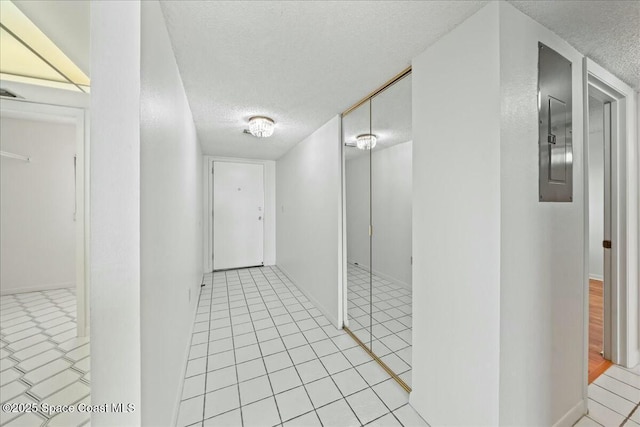 hall with light tile patterned flooring and a textured ceiling